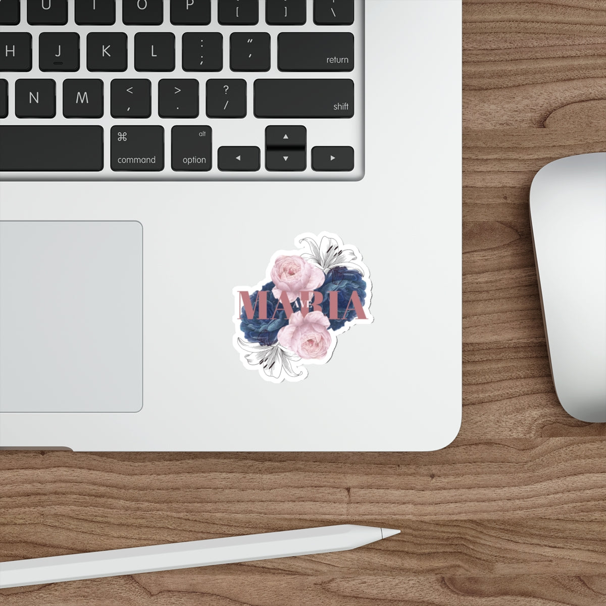 A sticker with a floral design and the text 'Ave Maria' in the center on a laptop.